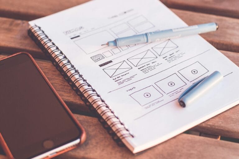 Notebook Beside the Iphone on Table - Credit picjumbo.com