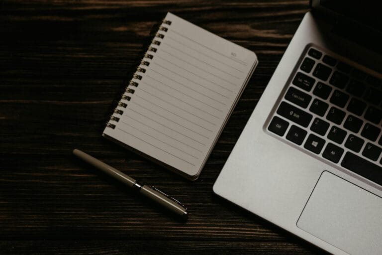 Notepad and a Laptop on Wooden Table - Credit Polina